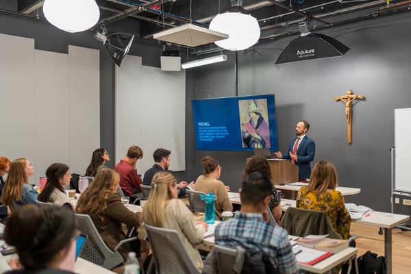 Teacher in classroom presenting a powerpoint to students.